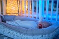 Portrait of a baby boy aged one month sleeping in a crib. Caucasian child in the childrens bedroom Royalty Free Stock Photo