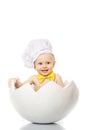 Portrait baby boy dressed in s chef`s hat sitting in egg shell. isolated on white background. Children`s Emotions Royalty Free Stock Photo