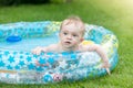 Portrait of adorable baby boy lying in inflatable swimming pool at house backyard Royalty Free Stock Photo