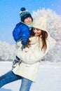 Portrait of baby boy and mother in winter day - snow is falling