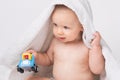 Caucasian, cheerful child after bath playing with a toy. White background. Royalty Free Stock Photo