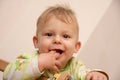 Portrait of a baby boy who holds his two fingers in his mouth Royalty Free Stock Photo