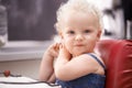 Portrait, baby and child on a high chair in kitchen at home alone, healthy and adorable. Face, toddler and cute blonde Royalty Free Stock Photo