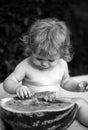 Portrait of baby child outdoors. One year old baby boy eating watermelon slice in the garden. Royalty Free Stock Photo