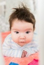 Portrait of a baby in the crib. High angle portrait of a beautiful baby with a finger in his mouth, lying on the bed, his eyes Royalty Free Stock Photo