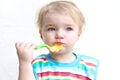 Portrait of baby eating porridge with spoon Royalty Free Stock Photo