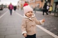 Portrait of baby girl in coat and hat laughing. Cute baby outside Royalty Free Stock Photo