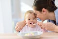 Portrait of baby girl eating lunch with her mother Royalty Free Stock Photo