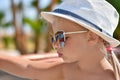 Portrait of a baby girl in glasses and a white hat at the resort Royalty Free Stock Photo