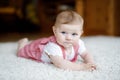 Portrait of baby girl in white sunny bedroom. Newborn child learning crawling. Nursery for children. Textile and bedding Royalty Free Stock Photo