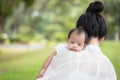 Portrait of baby in the mother`s embrace in the park. concept of duties of wife and mother in raising children and family Royalty Free Stock Photo