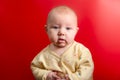 Portrait of a baby on a red background, newborn girl close-up in the studio Royalty Free Stock Photo