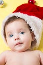 Portrait of baby in a red Santa hat with balls on the New year tree. Beautiful little celebrates Christmas. holidays.