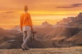 Portrait from the back of the girl traveler photographer in an orange sweater and hat with a camera in hand in the