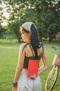 Portrait back side Asian woman in casual wear hiding her book at back side in a park