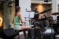 Portrait on back view of blond teenager playing drums in the street