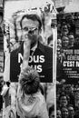 portrait on back view of a demonstrator tearing up a poster of emmanuel macron president of the french republic