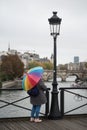 woman standing on the famous bridge of arts in Paris with a rainbow umbrella Royalty Free Stock Photo