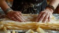 A portrait of a bakers hands adorned with rings and bracelets skillfully rolling out thin layers of filo pastry for a