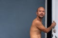 Portrait of bald beard Japanese man open white door with blue house wall