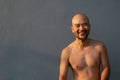 Portrait of bald beard 40s topless Japanese man on grey blue background