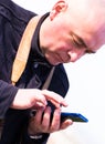 Portrait of bald elderly man looking at smartphone