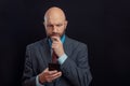 Portrait of bald male business man on dark background. Man in his 40s with grey beard, wearing classic suit, blue shirt, and red Royalty Free Stock Photo