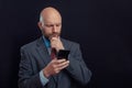 Portrait of bald male business man on dark background. Man in his 40s with grey beard, wearing classic suit, blue shirt, and red Royalty Free Stock Photo