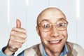 Portrait Bald man with glasses shows a thumb up and smiles Royalty Free Stock Photo