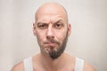 Portrait of a bald man with a half beard. An angry guy thinks to shave him or not. Funny concept of good and evil in one person. A