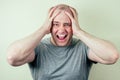 A portrait of a bald man is sad against a gray background. problem of male pattern baldness. sadness, vexation and anger Royalty Free Stock Photo