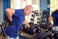 A portrait of senior man feeling strong back pain during training in the gym. People, healthcare and lifestyle concept Royalty Free Stock Photo