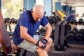 A portrait of senior man feeling strong knee pain during training in the gym. People, healthcare and lifestyle concept Royalty Free Stock Photo