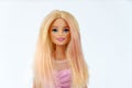 Portrait of a Barbie doll with loose blond hair in a pink dress on a white background. Portrait of a Barbie