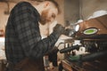 Portrait of a barista`s husband steaming milk for cappuccino on a professional coffee machine. Concentrated barista owner prepare Royalty Free Stock Photo