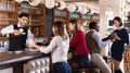 Portrait of barman and people who are standing near bar counter in luxurious restaurant