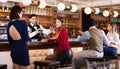 Portrait of barman and people who are standing near bar counter in luxurious restaurant Royalty Free Stock Photo