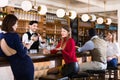 Portrait of barman and people who are standing near bar counter in luxurious restaurant Royalty Free Stock Photo