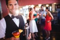 Bartender standing with cocktail glass and cocktail shaker in nightclub Royalty Free Stock Photo