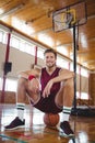 Portrait of basketball player sitting on ball Royalty Free Stock Photo