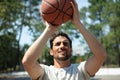 portrait basketball player taking jump shot outdoors