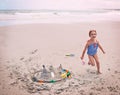 Portrait, beach and little girl running with sandcastle outdoor by sea or ocean for carefree fun. Nature, water and Royalty Free Stock Photo