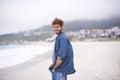 Portrait, beach and man with a smile, vacation and summer holiday with weekend break and water. Waves, face and person Royalty Free Stock Photo