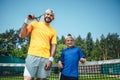 Positive man and boy holding tennis rackets Royalty Free Stock Photo