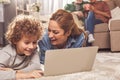 Cheerful mother and kid looking at laptop