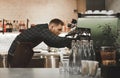 Portrait of a bearded barista cleans a professional coffee machine after cooking. Bartender is preparing coffee machine at the
