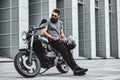 Portrait of bearded biker chilling with his motorbike