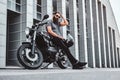 Portrait of bearded biker chilling with his motorbike