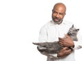 Portrait of a bearded bold African American man holding a grey cat with yellow eyes on white background with Copy-space area