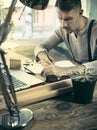 Portrait of a bearded businessman who is checking details of his upcoming meeting in his notebook and typing. Royalty Free Stock Photo